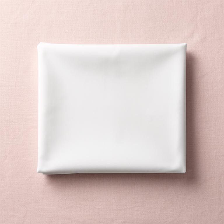 Crisp sheet folded into a neat square on a pale pink linen surface